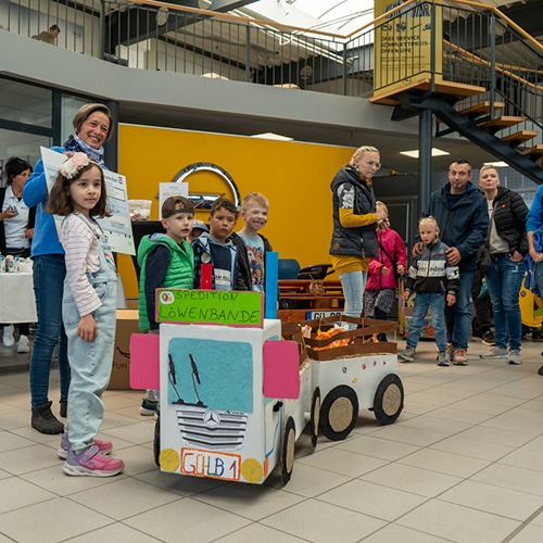kinder die einen lkw aus pappe gebaut haben